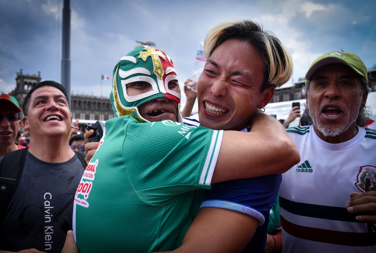 A Mexican and Japanese fan embrace during the 2026 FIFA World Cup group stage match between Japan and the Netherlands at the FIFA Fan Festival in Mexico City's Zocalo, Mexico