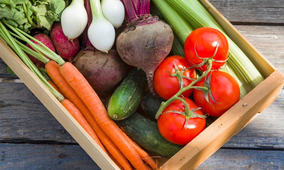 A wooden crate of fresh vegetables
