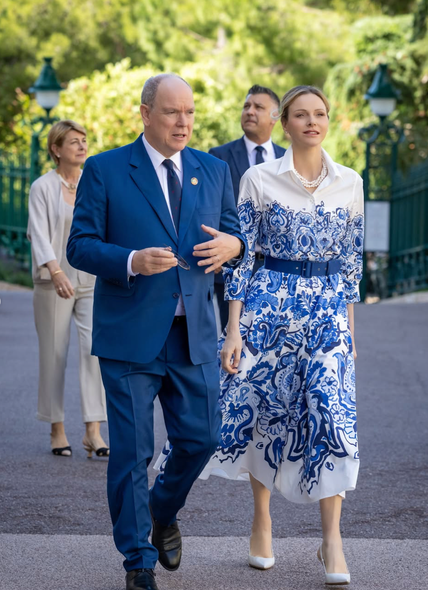 Princess Charlene paired her wave-print midi dress with statement pearls and a structured navy belt.