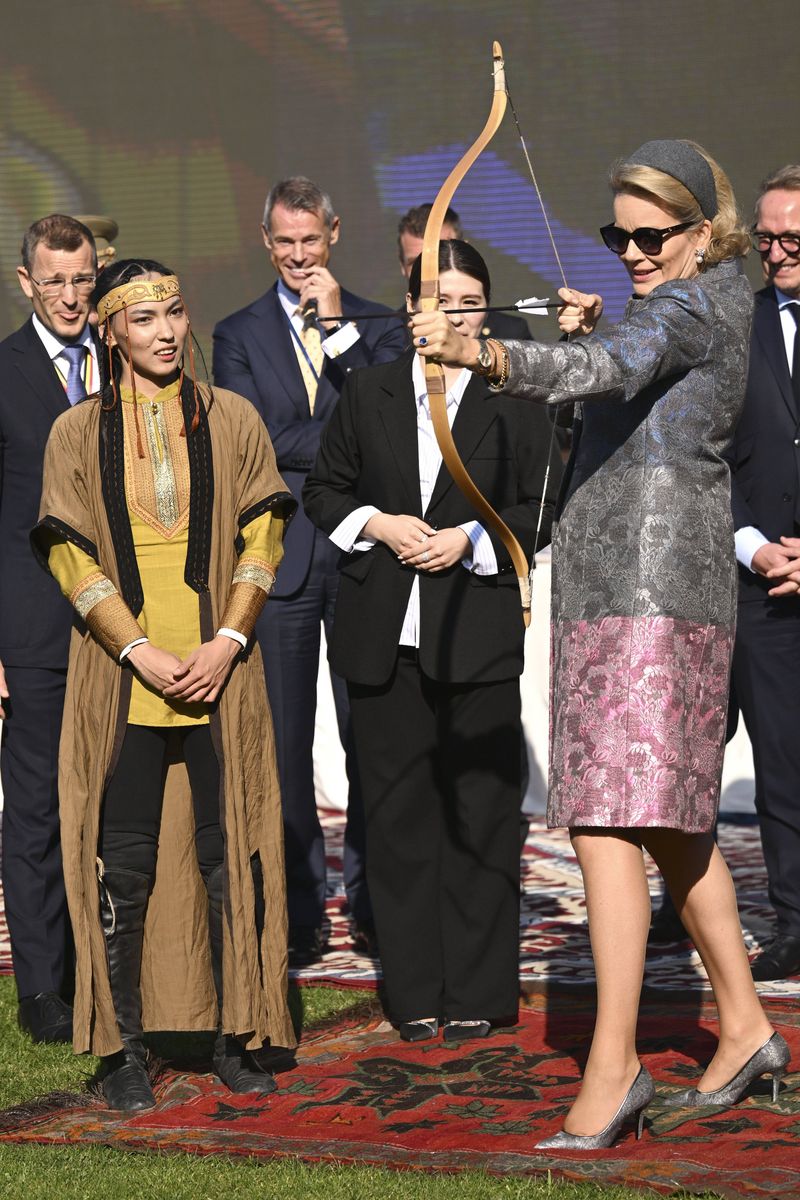 Mathilde tried her hand at archery in a floral coat, coordinating gray heels and a matching headpiece.