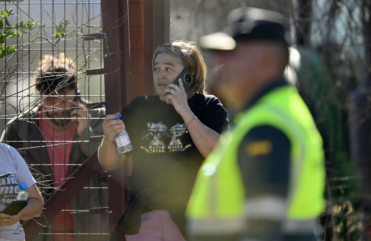 People make calls as emergency teams work at the scene of a collision involving two high-speed trains near Urda station in Toledo province, Spain, on October 28, 2026.