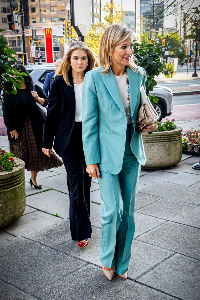 Queen Máxima stuns in a vibrant turquoise Max Mara suit, paired with nude Gianvito Rossi heels and a colorful statement necklace.