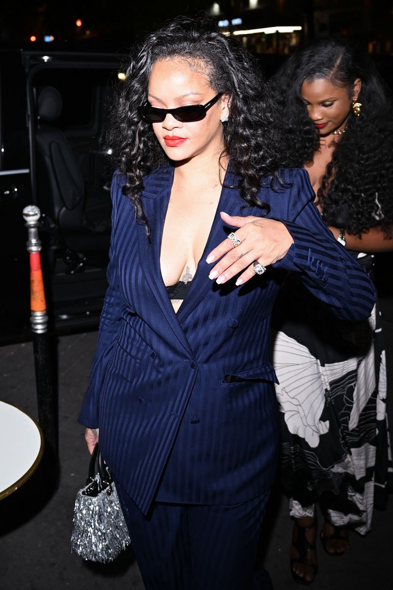 She styled the tailored ensemble with snake-print pointed-toe stilettos, narrow black sunglasses, a sparkling silver handbag and a visible black lace bralette.