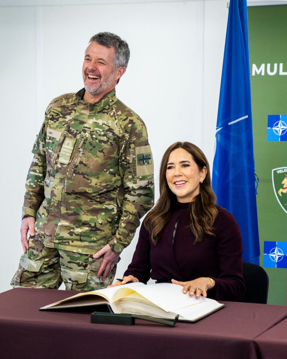 Queen Mary of Denmark and King Frederik X of Denmark react as they sign a guestbook during a visit to Adazi Military Base in Adazi, Latvia, on October 29, 2025. The two-day visit particularly focused on international military cooperation and culture.