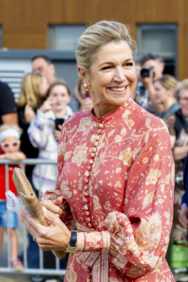 A high neckline, fabric-covered buttons and billowing sleeves give Máxima’s pink printed dress a romantic finish.