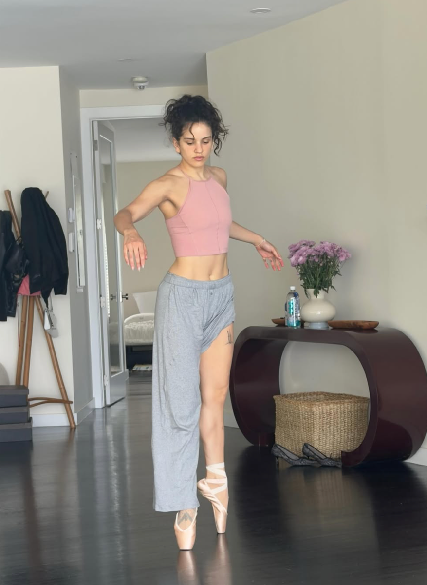 Dressed in a soft pink crop top and pointe shoes, Rosalía embraced a minimalist rehearsal look for the training session.