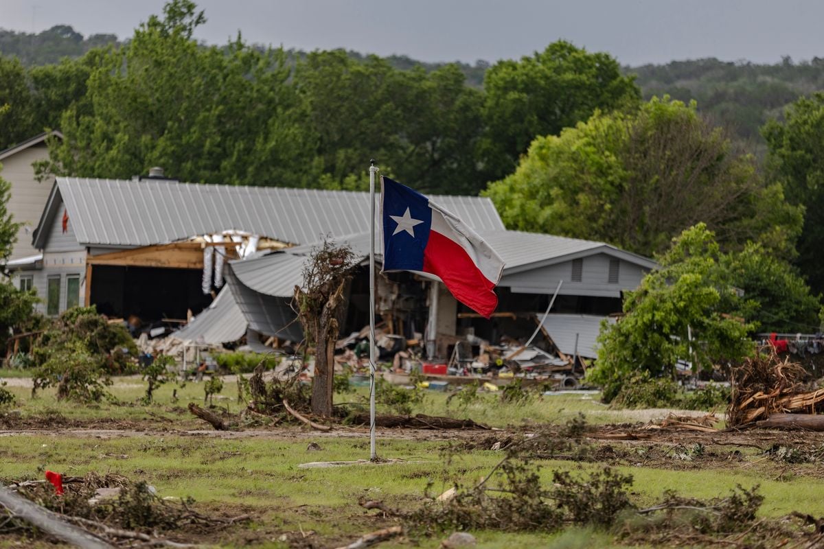  A Texas state flag flies in a yard filled with debris on July 6, 2025 in Hunt, Texas. Heavy rainfall caused flooding along the Guadalupe River in central Texas with multiple fatalities reported. (Photo by Jim Vondruska/Getty Images)