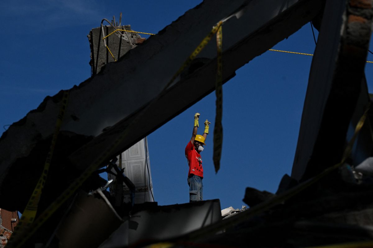 A volunteer gestures during the search for survivors amid the rubble of a collapsed house after an earthquake in Cali, Colombia, on August 11, 2026.