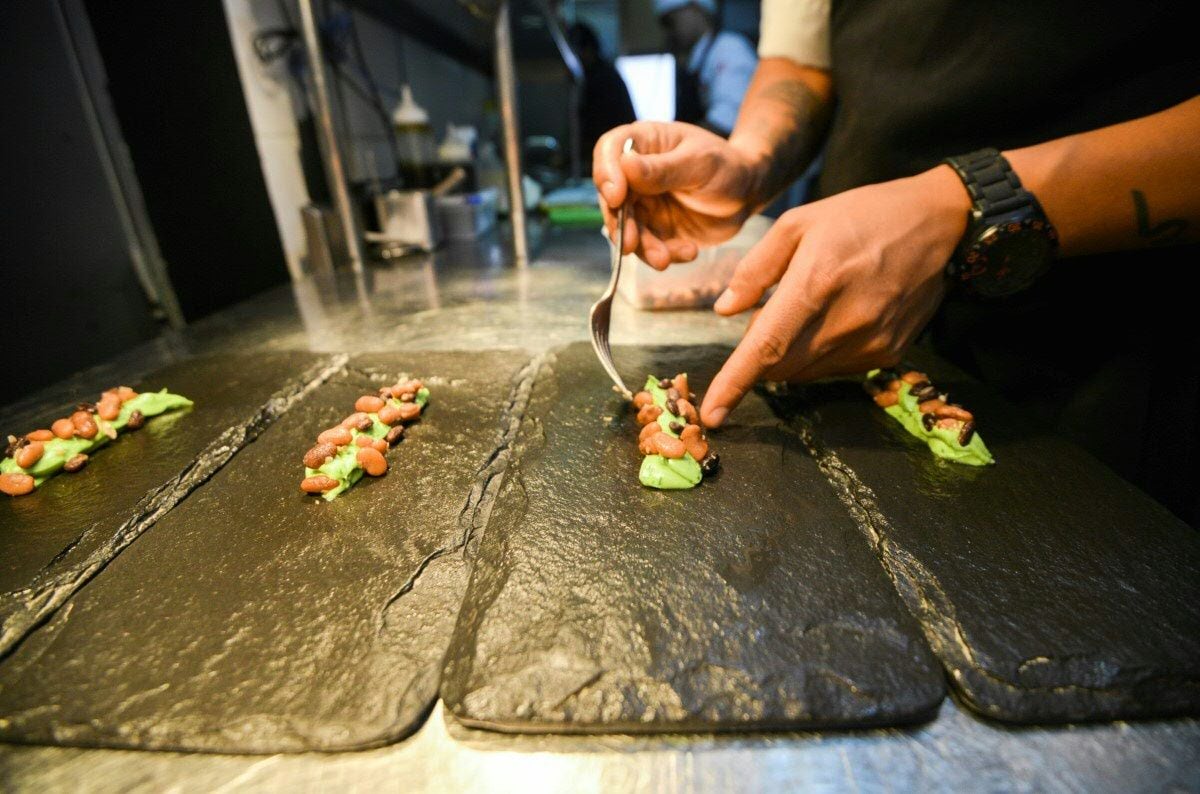 A cook places final touches on a dish created by Peruvian Nikkei chef Mitsuharu Tsumura, known as Misho, at the Maido high-cuisine restaurant in Lima on June 17, 2016.