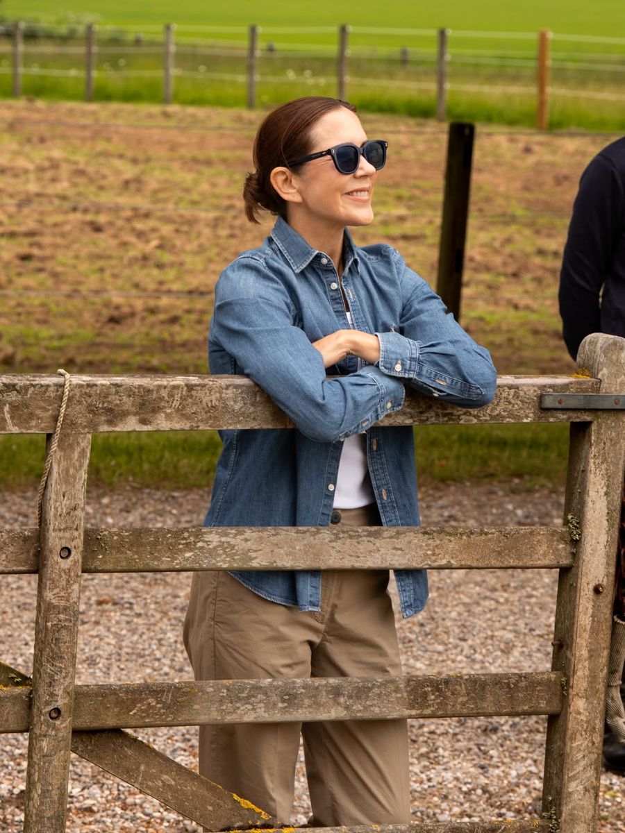Queen Mary embraced countryside chic in a classic denim shirt and neutral separates during a visit to see the royal horses begin their summer holiday.