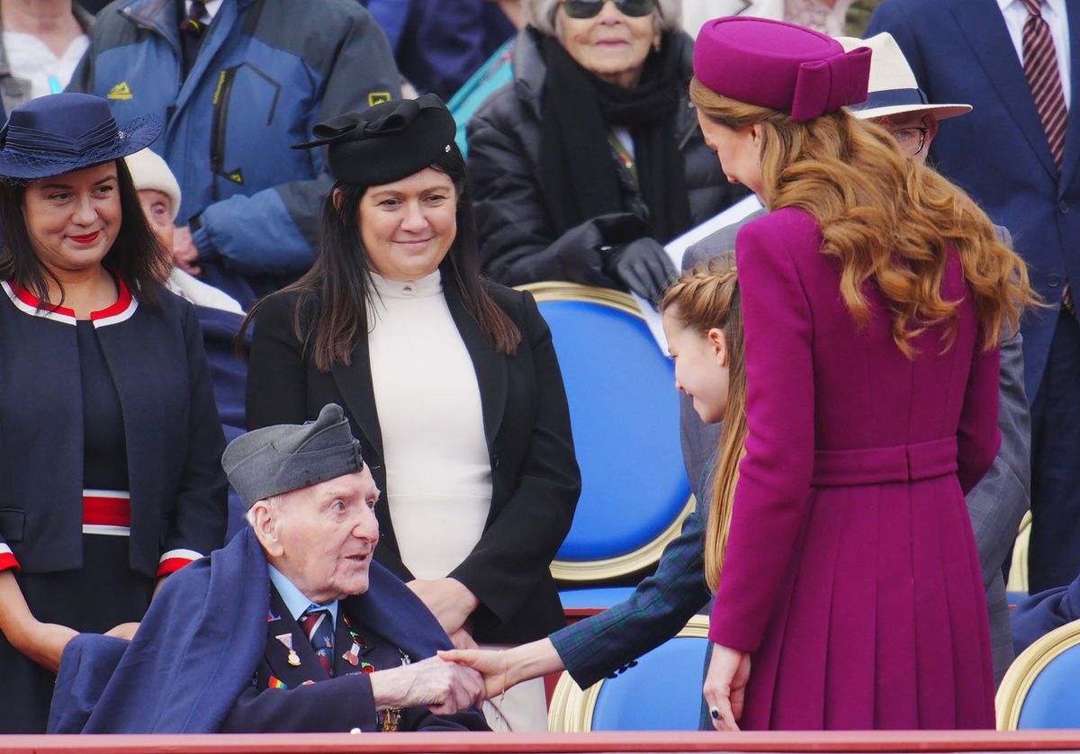 LONDON, ENGLAND - MAY 5: Princess Charlotte shakes hands with Second World War Veteran Bernard Morgan, watched by the Princess of Wales following the military procession for the 80th anniversary of VE Day, in honour of those who served during the Second World War, at Buckingham Palace on May 5, 2025 in London, England. Around 1300 members of the armed forces, including the Royal Navy, the Royal Marines, the British Army and the Royal Air Force, along with Commonwealth nations, Ukraine, and Nato allies are taking part in the military procession for Victory in Europe Day, which is celebrated each year on May 8, marking the day the Allies formally accepted Germany's surrender in 1945. (Photo by Ben Birchall - WPA Pool/Getty Images)
