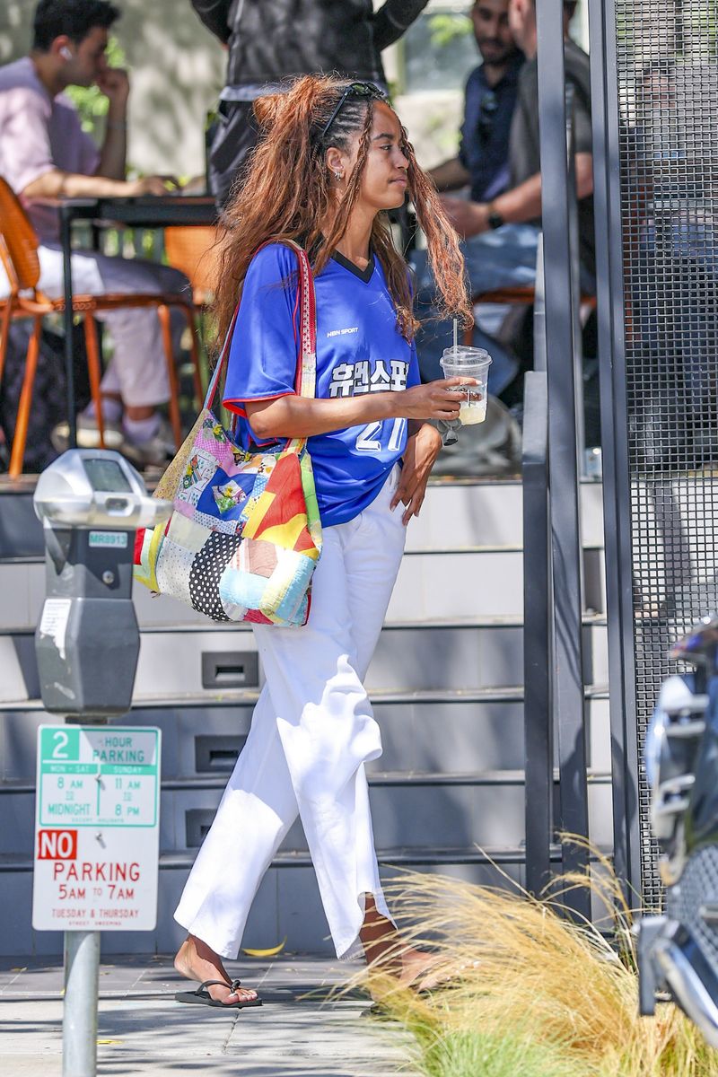 A day later, Malia switched up her summer staples for an oversized blue sports jersey inspired by South Korea's 1998 World Cup kit.