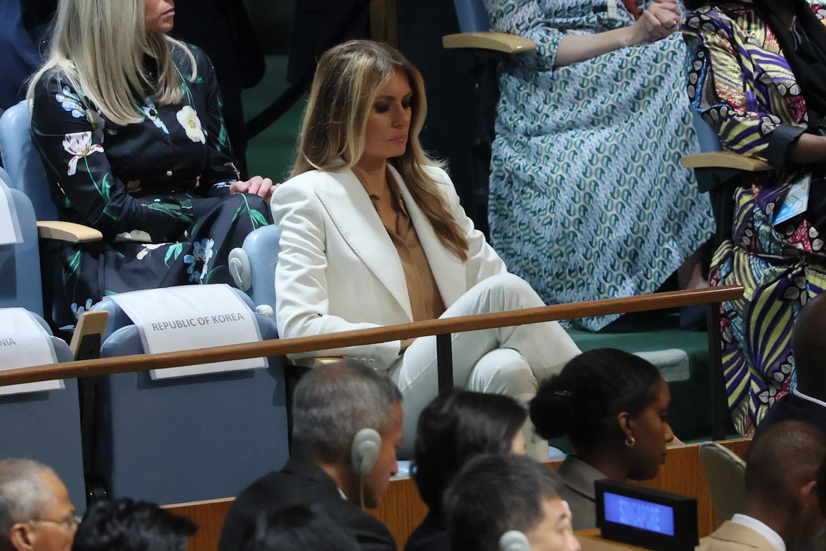 First Lady Melania Trump stepped into the spotlight with a refined fashion choice, which included a crisp white pantsuit from Dolce & Gabbana, cinched at the waist, layered over a copper-toned blouse from Max Mara. 