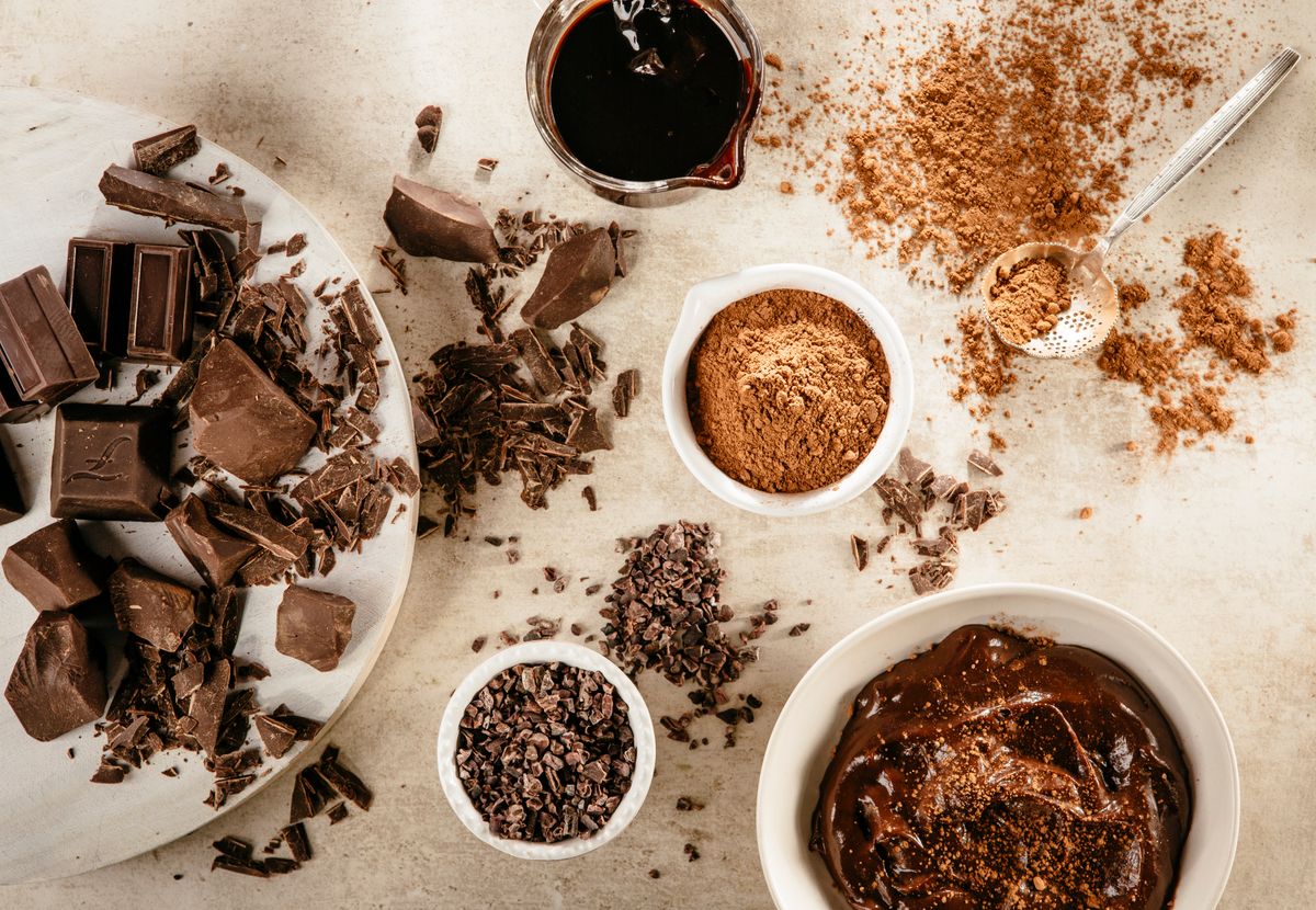 overhead view of chocolate chunks, nibs, sauce and pudding