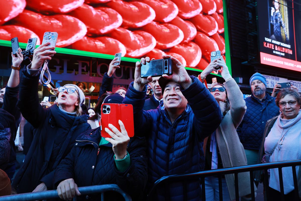 People watch as the New Year's Eve ball drop numerals for 2026 are lit up and displayed in Times Square.
