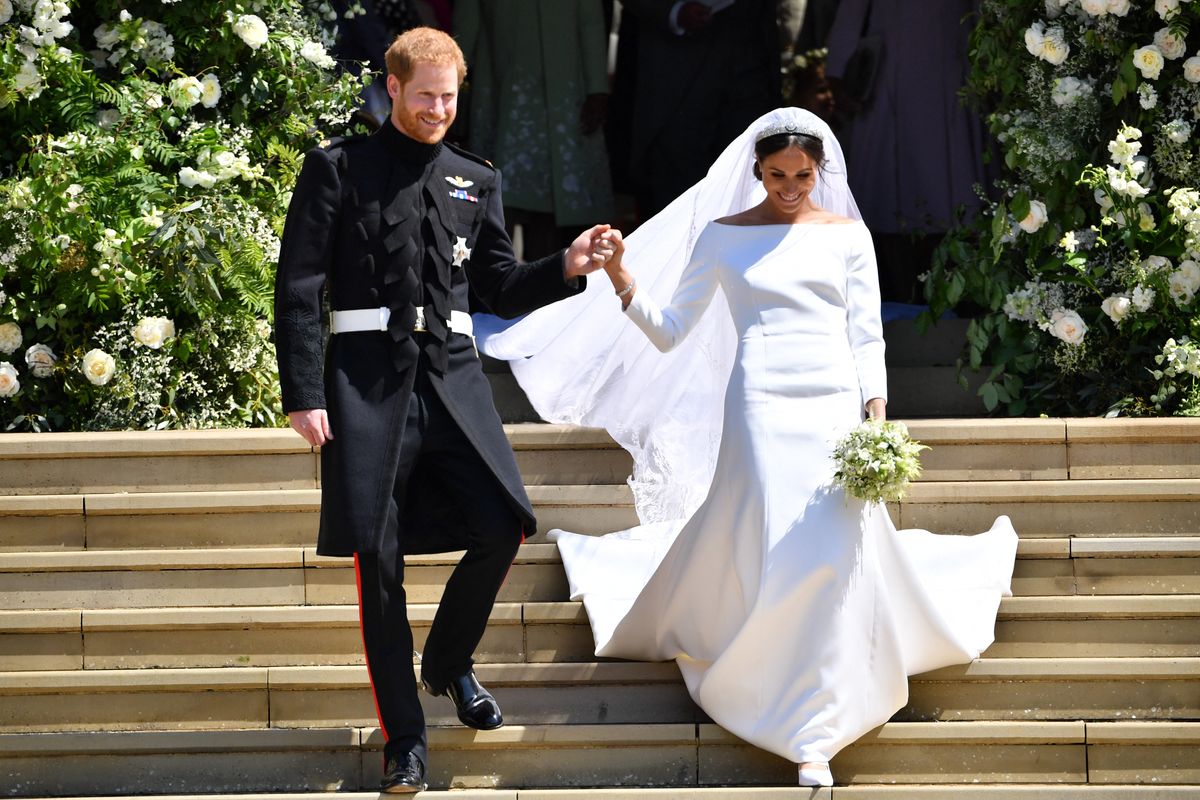 TOPSHOT - Britain's Prince Harry, Duke of Sussex and his wife Meghan, Duchess of Sussex emerge from the West Door of St George's Chapel, Windsor Castle, in Windsor, on May 19, 2018 after their wedding ceremony. (Photo by Ben STANSALL / various sources / AFP) (Photo by BEN STANSALL/POOL/AFP/AFP via Getty Images)
