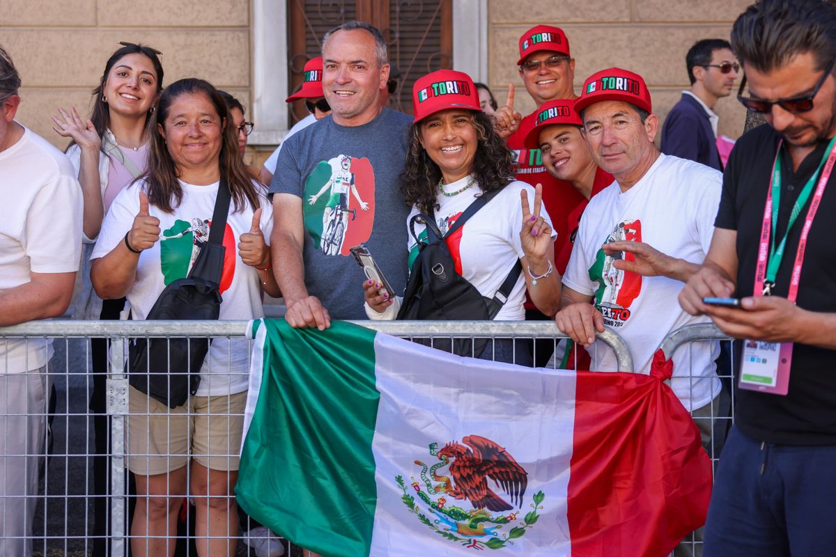 Fans from Mexico smile during the 108th Giro d'Italia 2025, Stage 18 as they cheer on Isaac