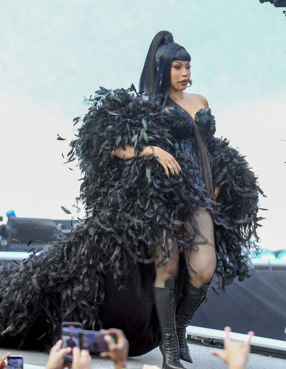 
Cardi B wore a dramatic black feathered cape over a matching corset dress, paired with fishnet tights and knee-high lace-up boots, as she hosted the 2025 WWE SummerSlam at MetLife Stadium. Her hair was styled in a sleek high ponytail.
***
Cardi B lució una capa dramática de plumas negras sobre un vestido con corsé a juego, medias de red y botas altas con cordones mientras fue la anfitriona del WWE SummerSlam 2025 en el MetLife Stadium. Llevó el cabello recogido en una alta cola de caballo.