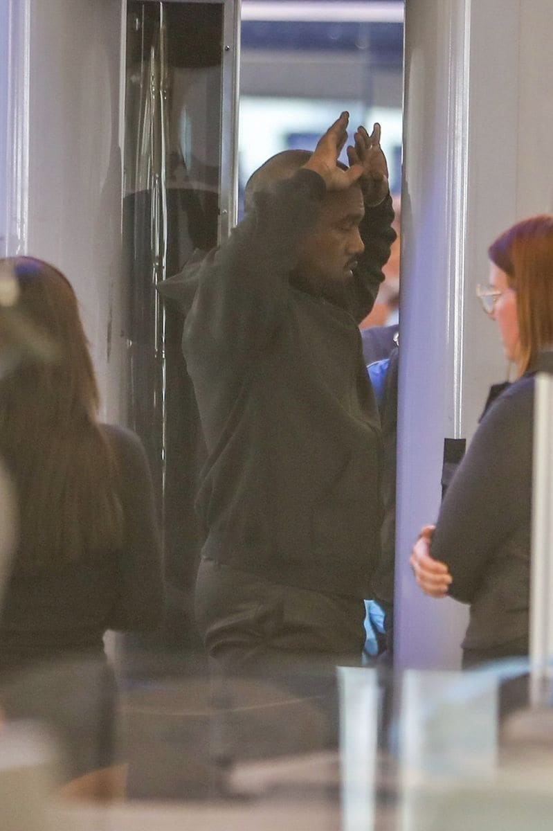Kanye stood silently as a TSA agent checked his passport, while Bianca turned heads in black micro shorts.