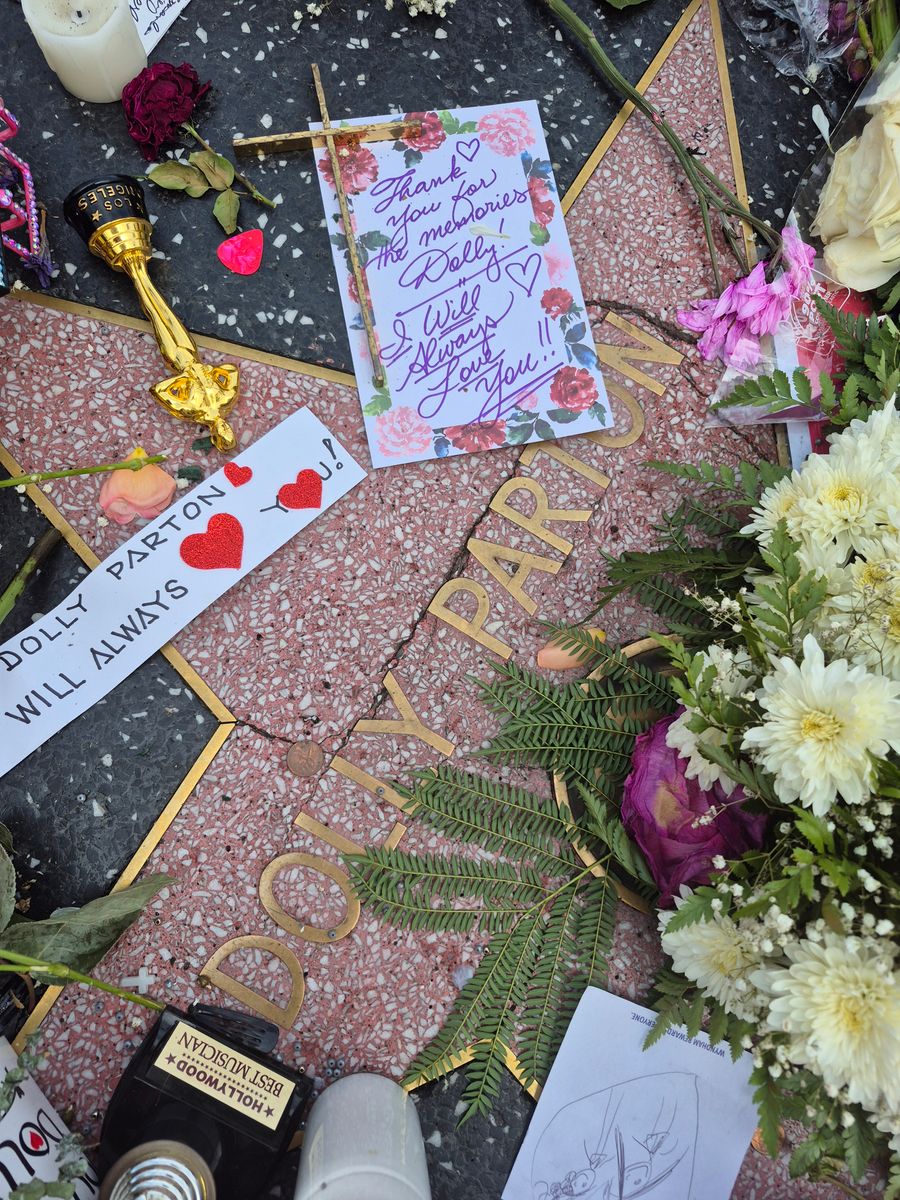 Flowers, notes and gifts in tribute to Dolly Parton are seen at her Star on the Hollywood Walk of Fame on August 27, 2026 in Los Angeles, California.