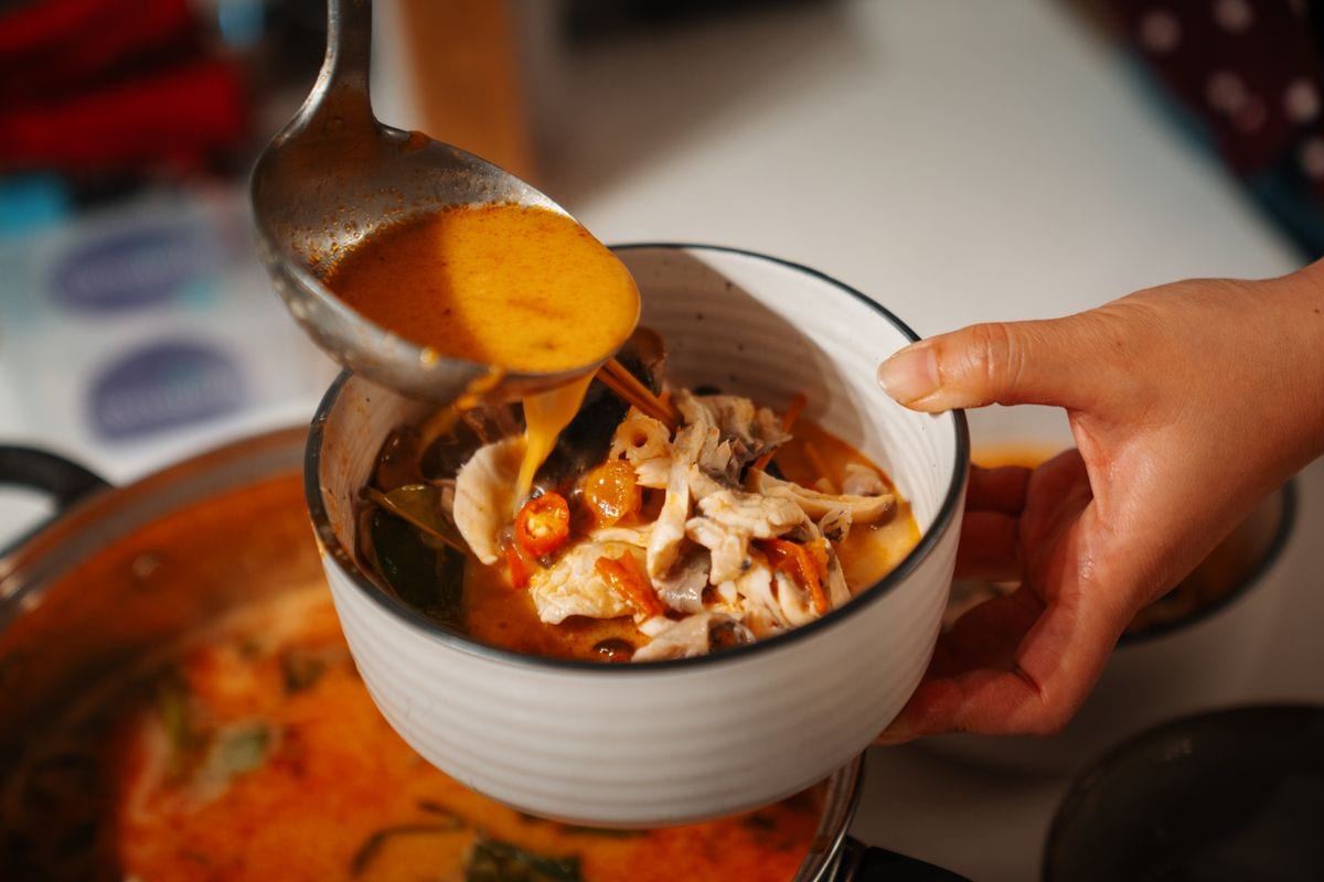 Homemade Tom Yum Soup features barramundi fish, squid, prawns, mussels, and mushrooms, infused with special Thai spices such as coconut milk, lemongrass, millet pepper, kaffir lime leaves, and galangal, creating a deliciously sour and spicy flavor.