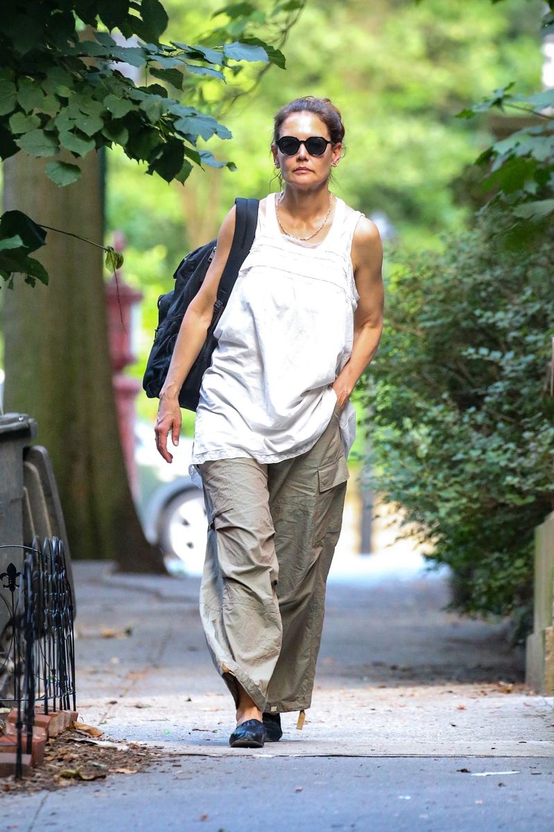 Actress Katie Holmes kept her ensemble baggy and comfy with a loose white tank top, cargo pants, and black flats during a solo outing in the hot streets of New York.