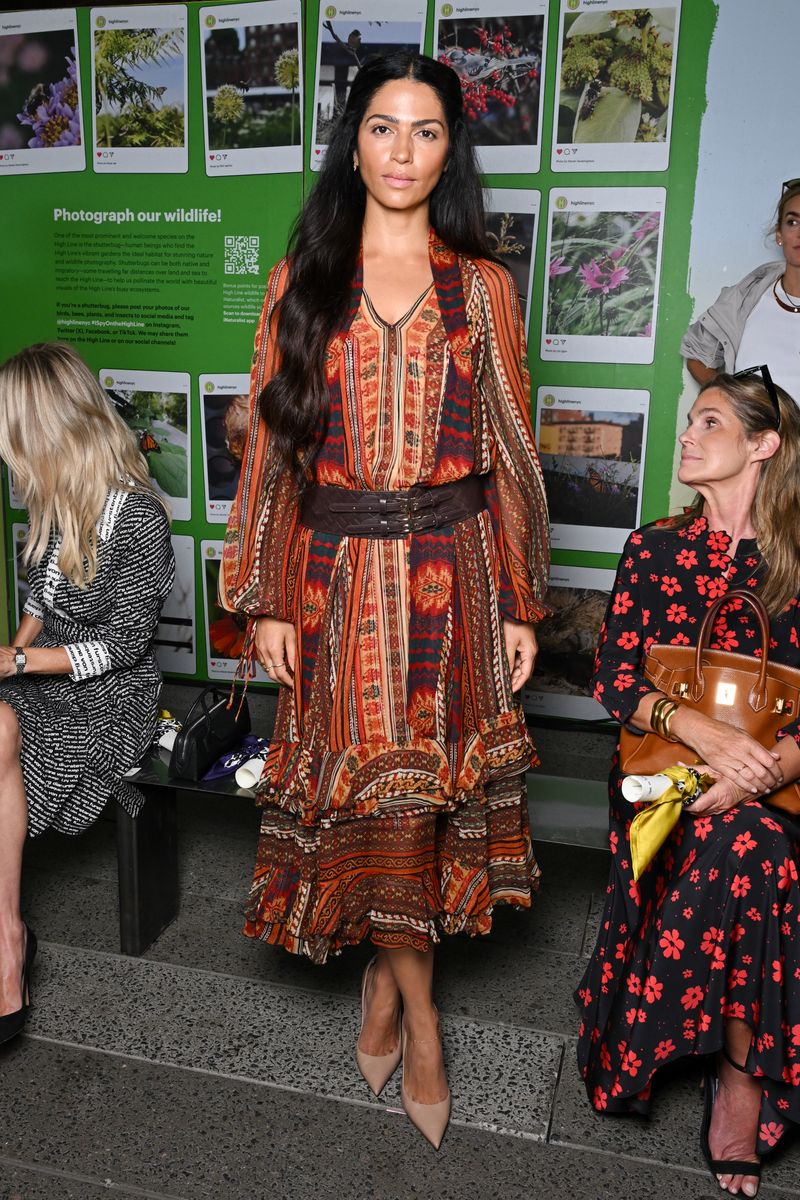 The model embraced bohemian glamour in a colorful patterned dress cinched at the waist with a wide brown belt and paired with nude pointed-toe pumps.