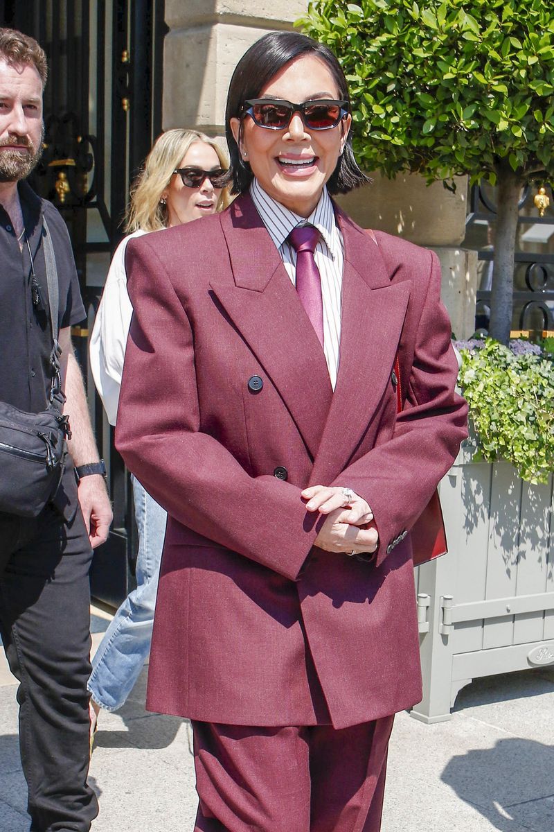 The day after testifying in the ongoing robbery trial, Kim Kardashian was seen leaving Ritz hotel with her mother Kris Jenner wearing a white dress and blue cap. Kris was wearing a burgundy woman suit combined with matching tie and shoes with black sunglasses.
