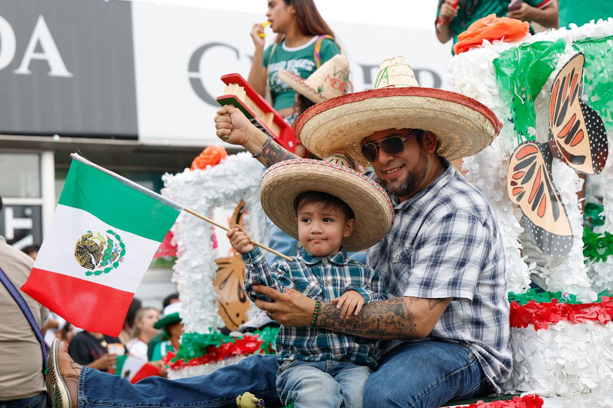 A young child waves a Mexican flag during the Mexican Independence Day parade