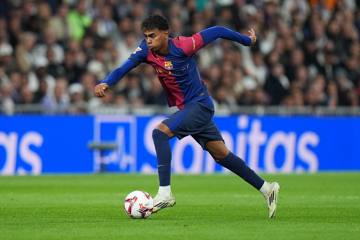Lamine Yamal of FC Barcelona runs with the ball during the LaLiga match between Real Madrid CF and FC Barcelona 