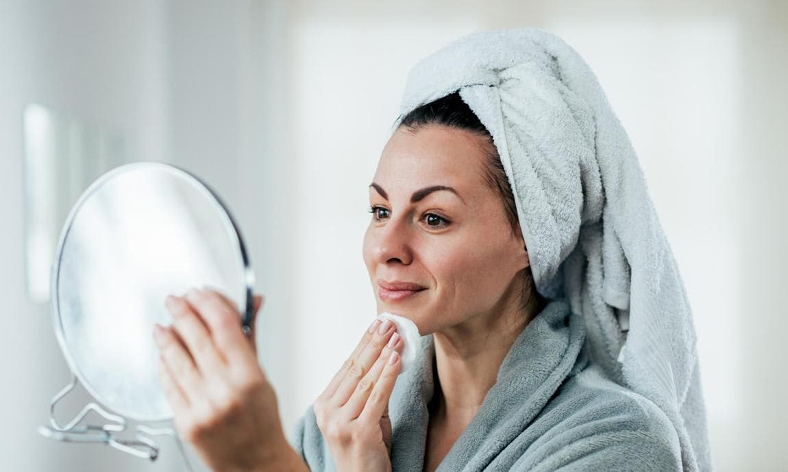 A picture of a woman cleaning her face.