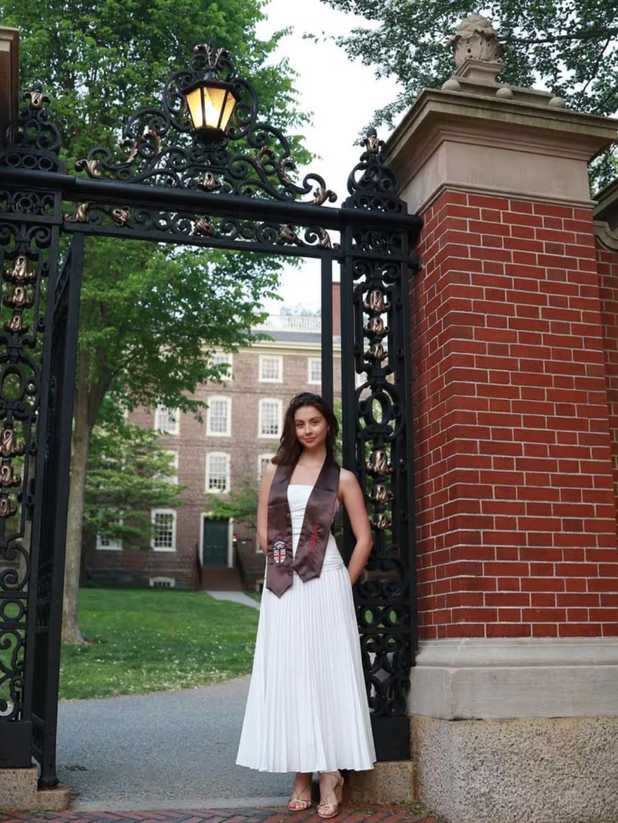 Carys, 22, poses at her alma mater's school