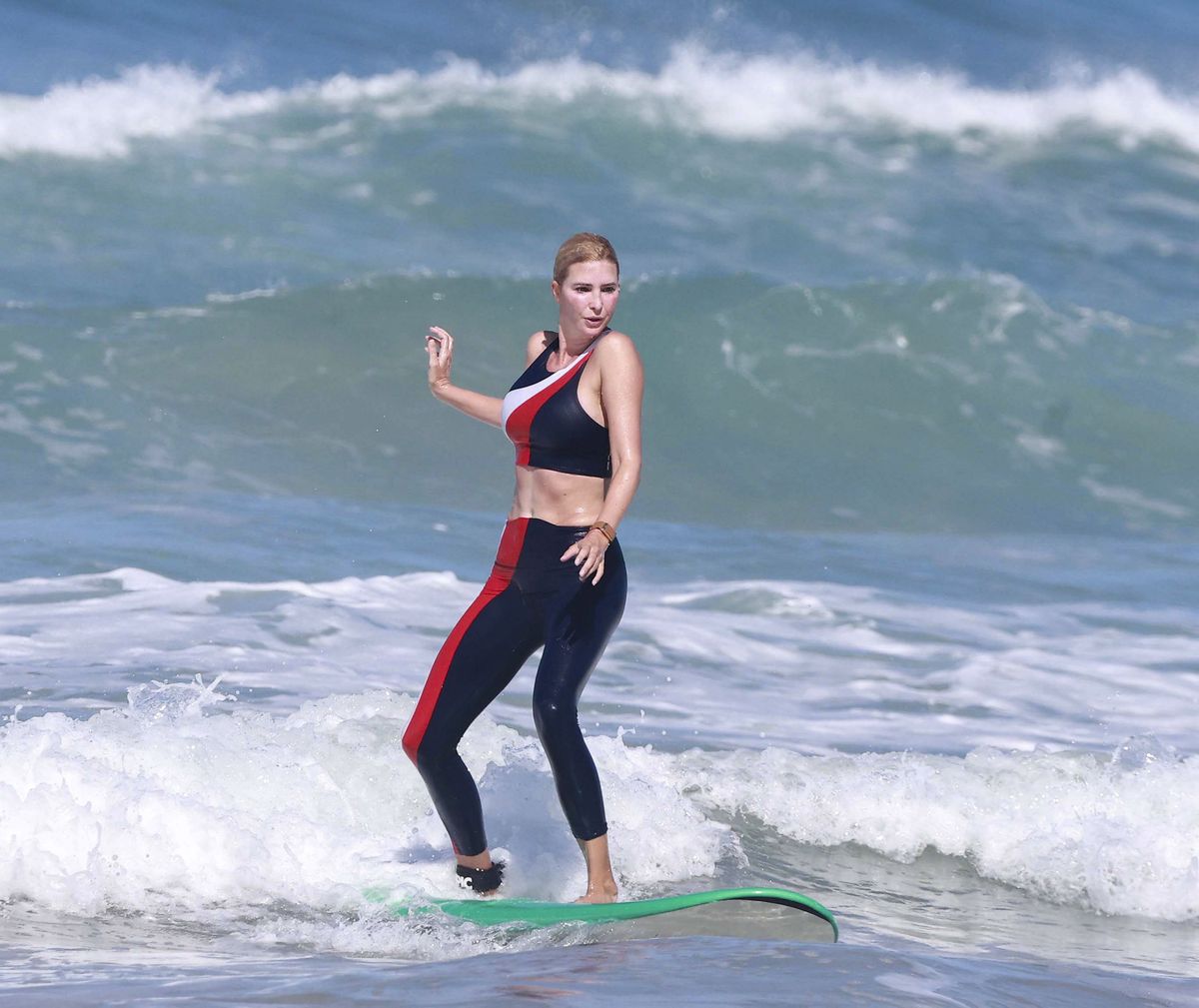 Ivanka kept her balance as she rode a wave toward the shore on a green-trimmed longboard.
