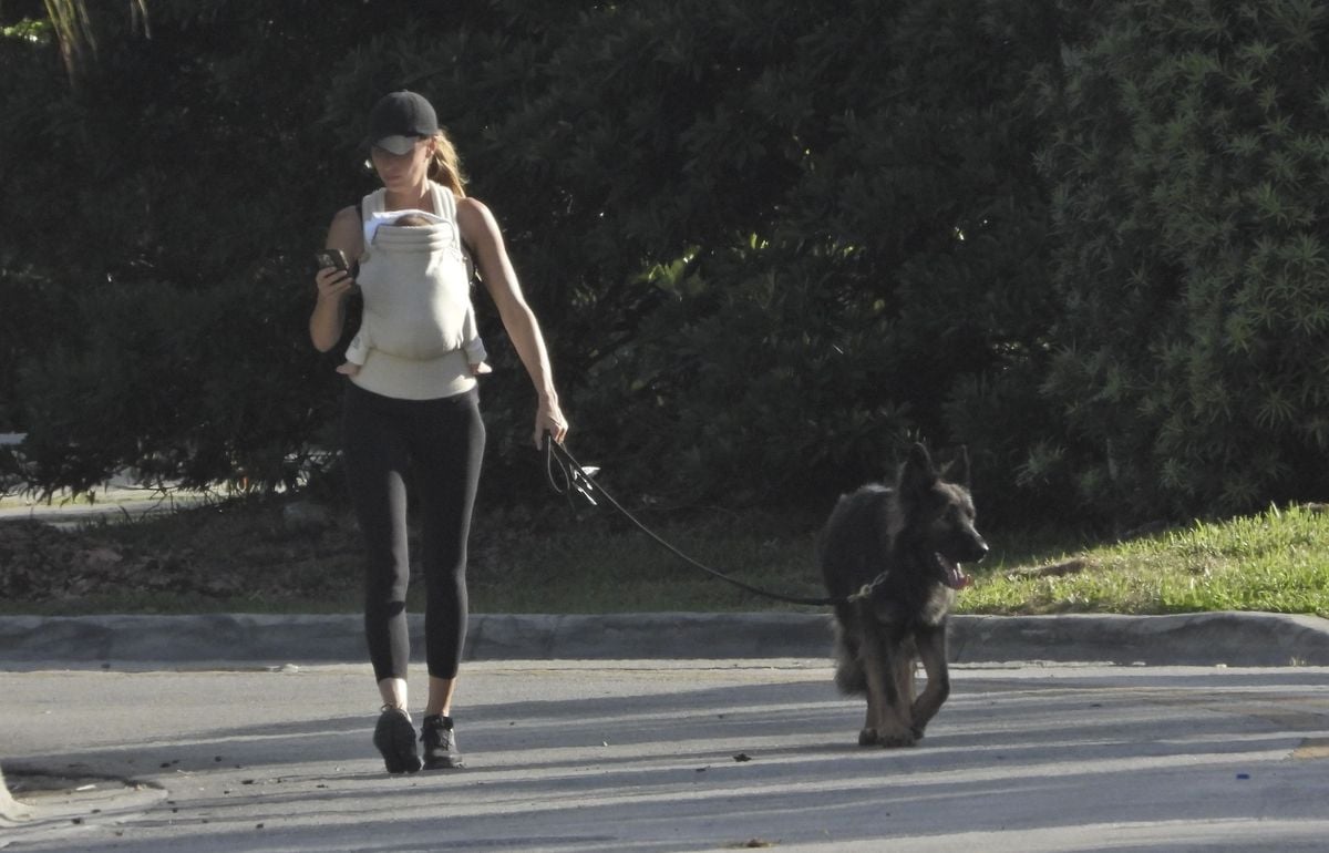 Gisele Bündchen shares a heartwarming moment while strolling through Miami, smiling with joy as she carries her newborn.