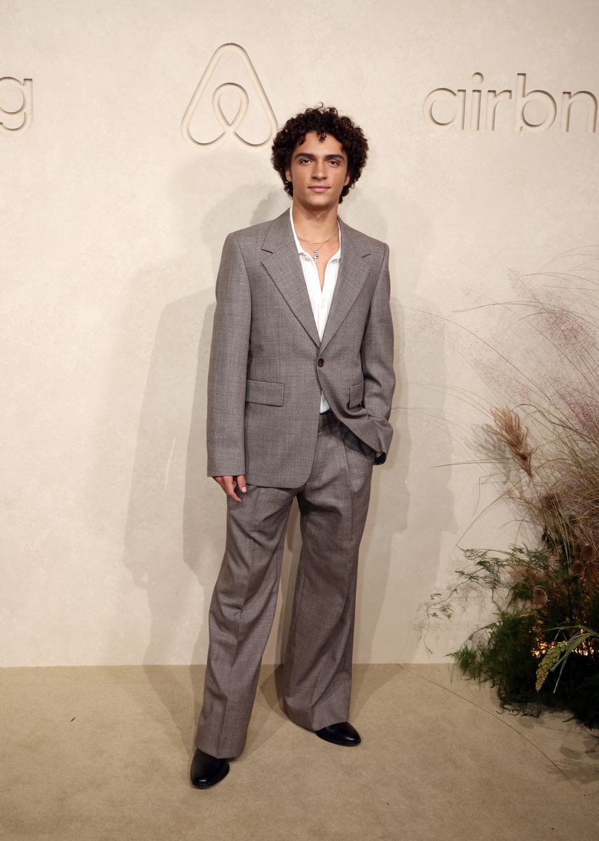 Levi paired his textured gray suit with an open-neck white shirt, layered necklaces and black shoes.