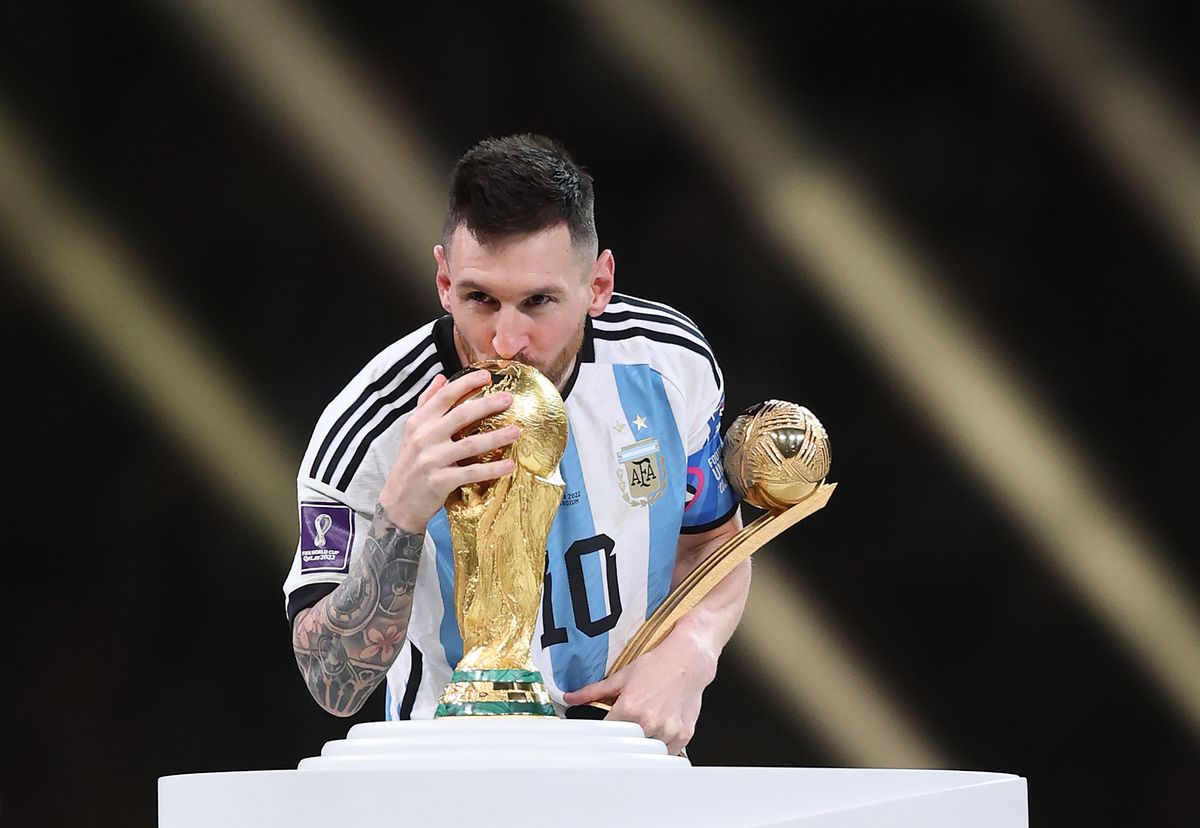 Lionel Messi of Argentina kisses the FIFA World Cup Qatar 2022 Winner's Trophy while holding the adidas Golden Boot award after the FIFA World Cup Qatar 2022 Final match between Argentina and France