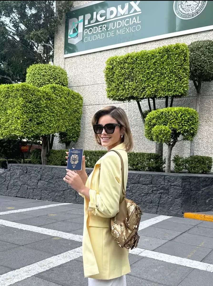 Aleska Génesis posed happily outside the Attorney General's Office, with her passport in hand, victorious at having been cleared of charges against her