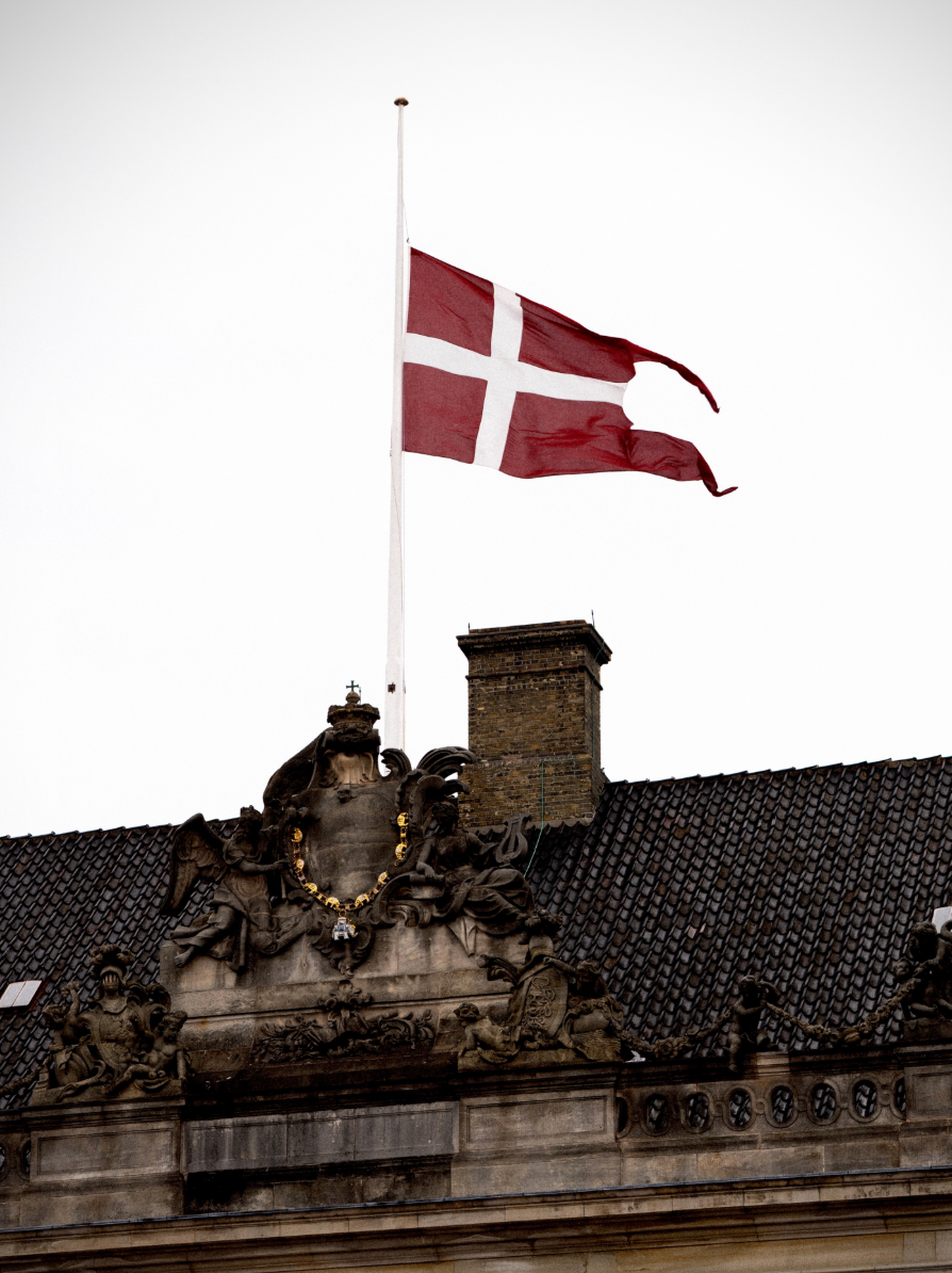 The Danish flag, known as the Dannebrog, flies at half-mast at Amalienborg Palace following the death of King Harald V.