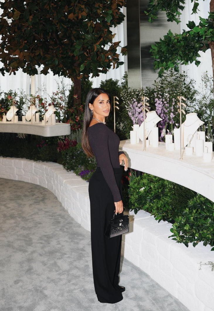 Her first look centered on a long-sleeved knit top paired with high-waisted tailored trousers