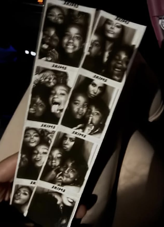 Kim Kardashian and her kids taking pictures inside a photo booth