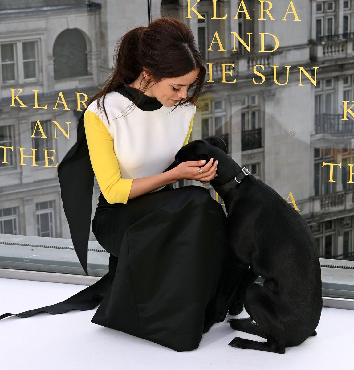 Jenna Ortega crouches beside Sig, gently holding the dog’s face during a sweet moment at the London photocall.