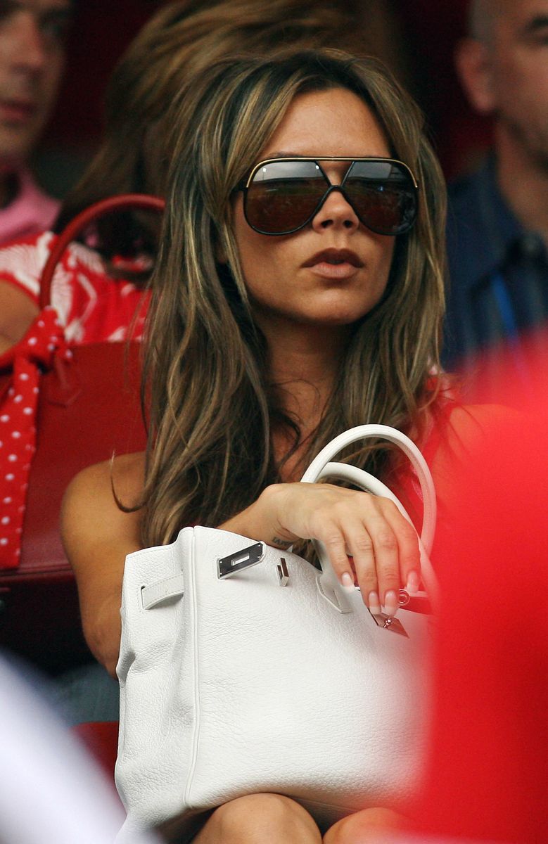 Victoria Beckham completed her iconic 2006 World Cup look with a white Hermès Birkin bag, ultra-short denim shorts, and oversized sunglasses. A A combination that helped define the WAG era