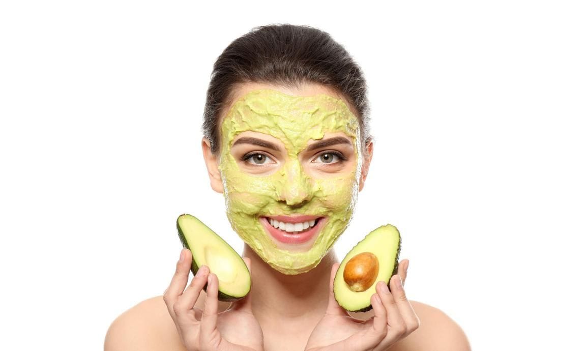Mujer con mascarilla de aguacate en su rostro