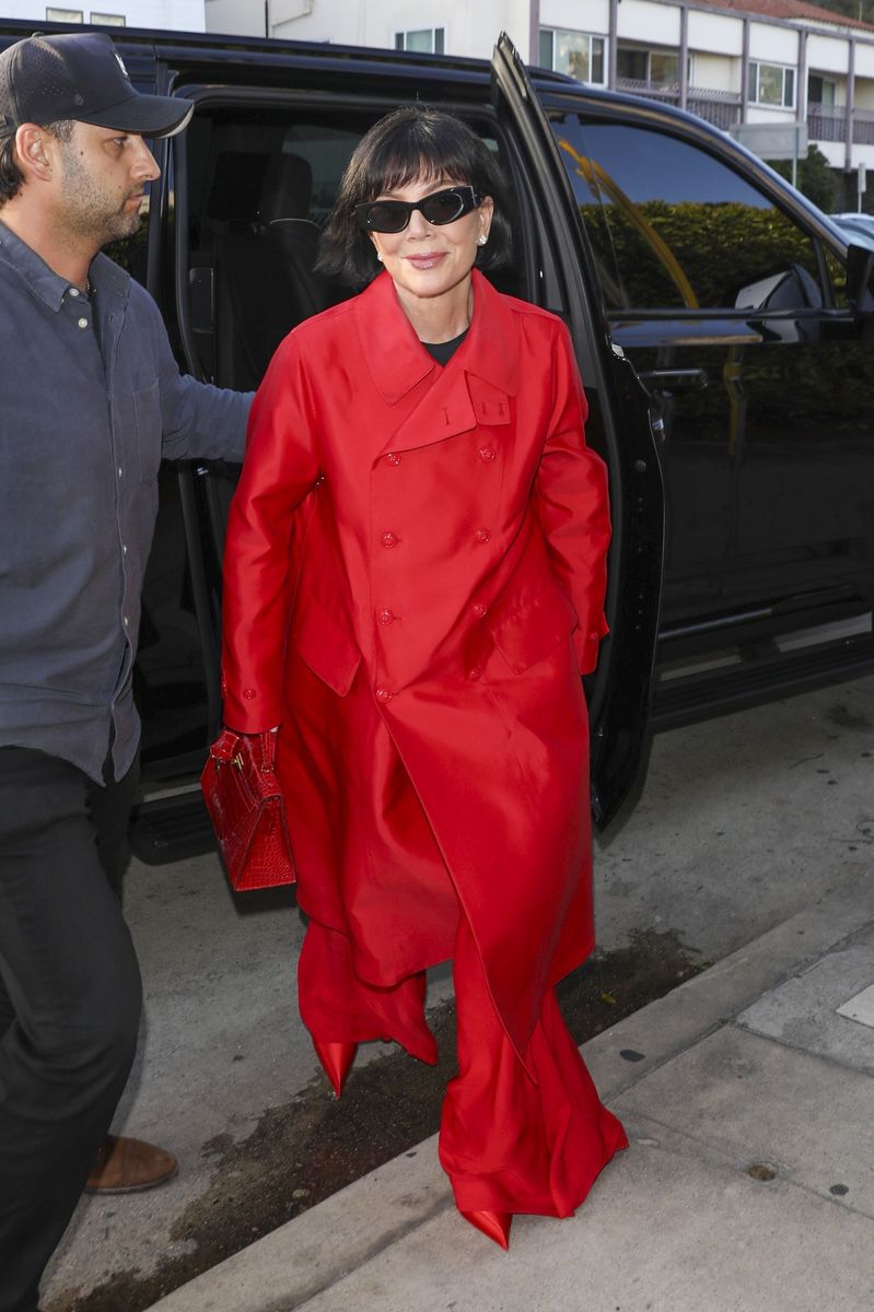 The Kardashian-Jenner matriarch embraced monochromatic dressing with a striking red coat, trousers, and pointed boots.