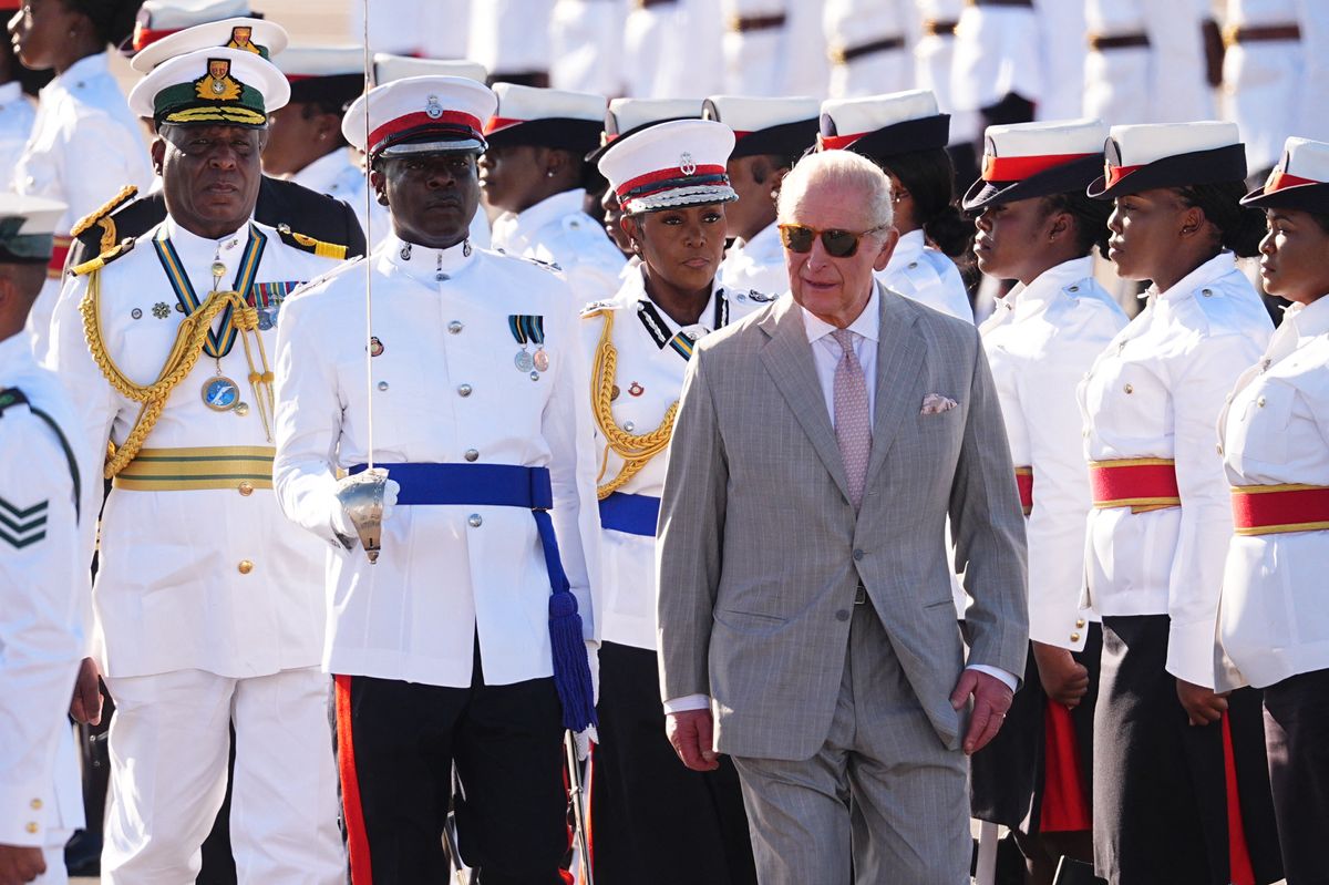 Britain's King Charles III walks by the guard of honour, made up of members of the Royal Bahamas Police Force and the Royal Bahamas Defence Force, as he arrives at Lynden Pindling International Airport, in Nassau