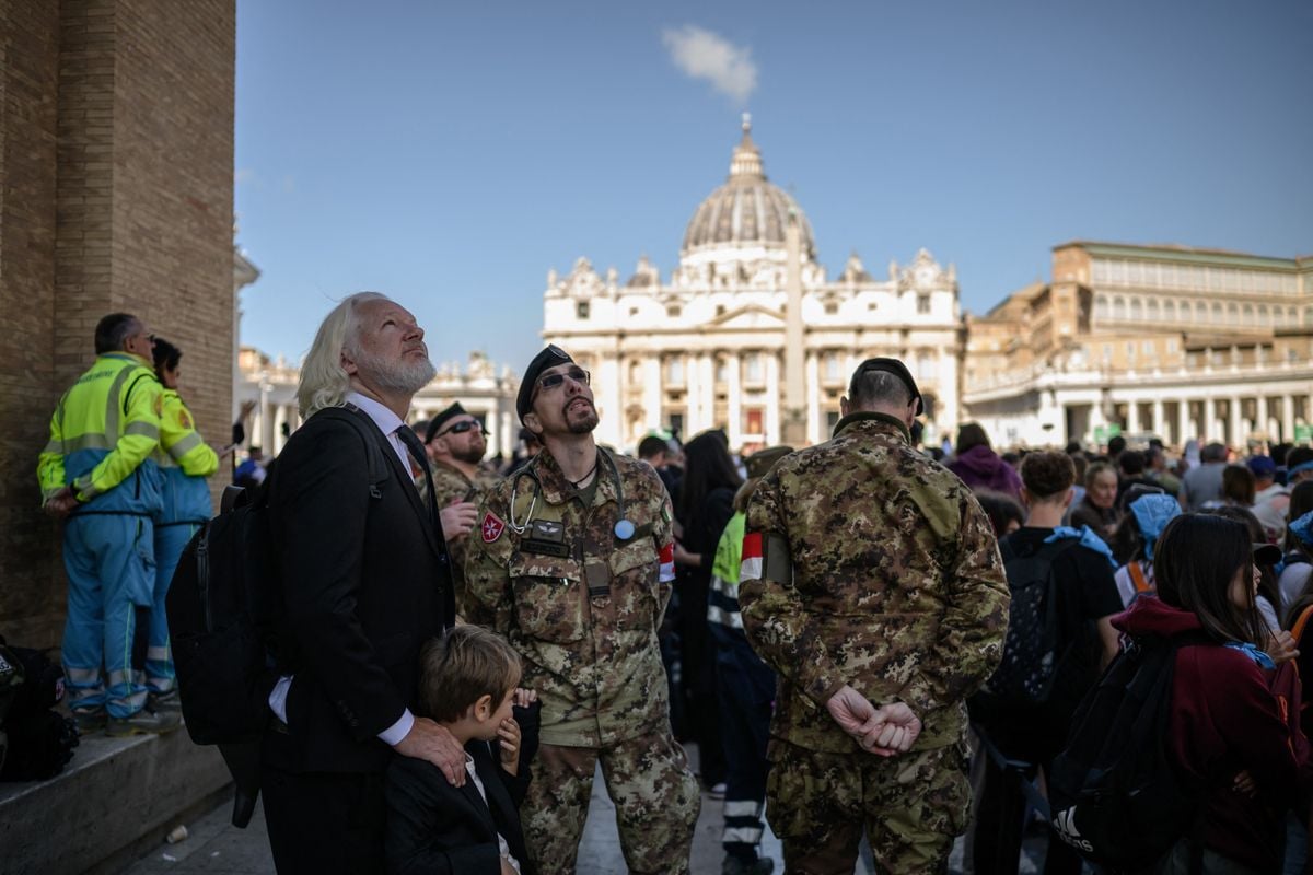 WikiLeaks founder Julian Assange (L) stands in Via della Conciliazione by St Peter's Square in The Vatican on April 26, 2025 during late Pope Francis' funeral ceremony.       