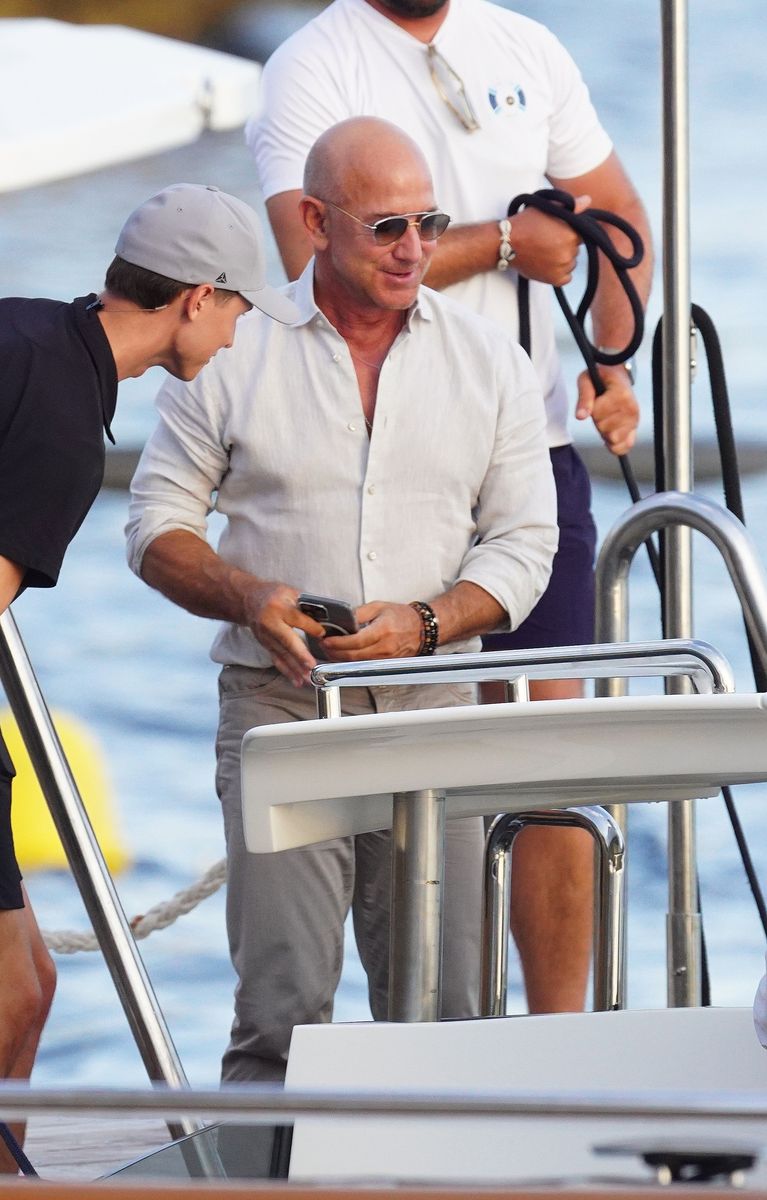 Jeff Bezos kept his look understated in a white linen button-up, gray pants, and his signature silver aviators, letting Lauren shine.
