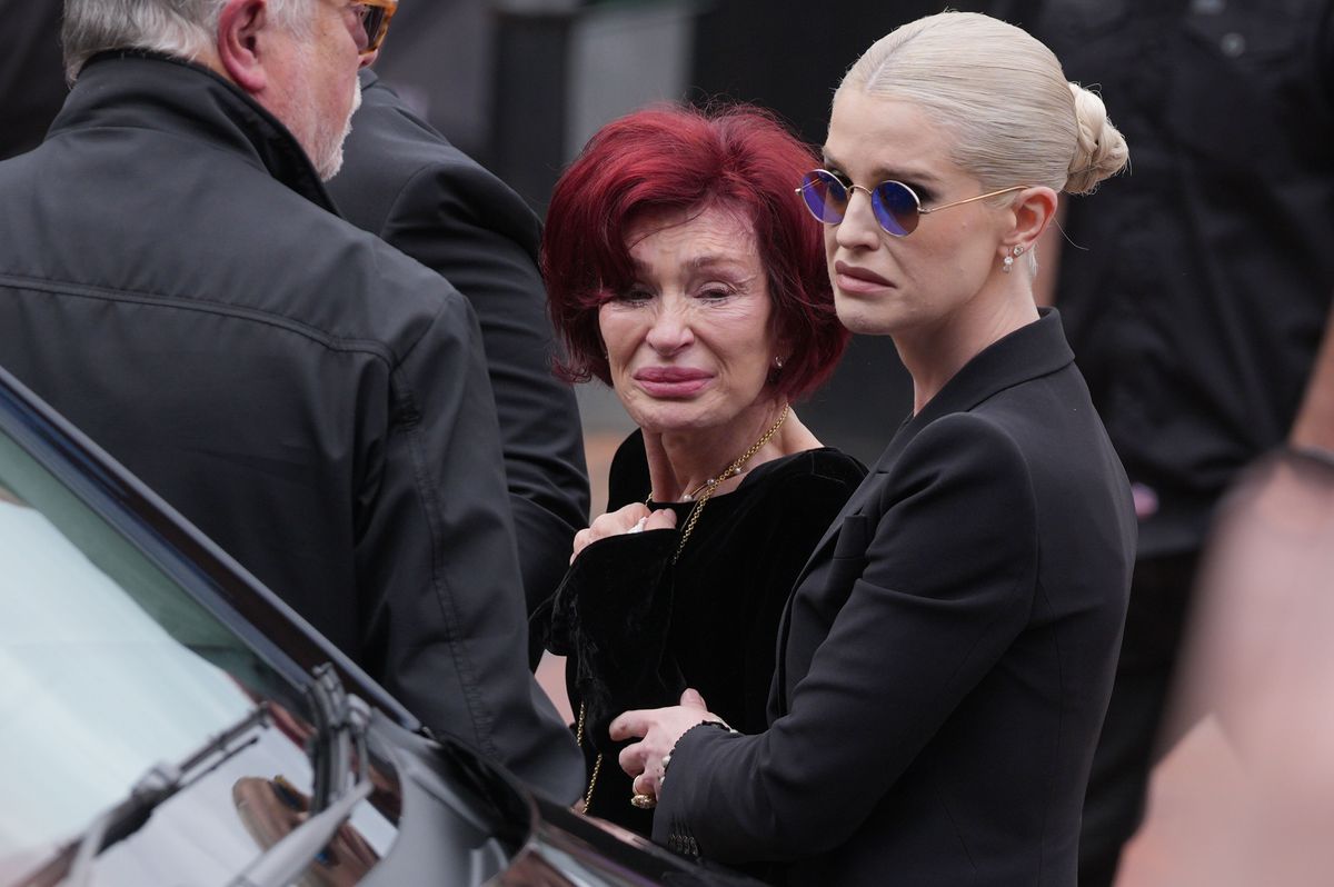 Sharon Osbourne and Kelly Osbourne stop to view tributes to the late Ozzy Osbourne from fans at Black Sabbath Bench and Bridge as his funeral cortege travels through his home city of Birmingham on July 30, 2025 in Birmingham, England. The Black Sabbath frontman passed away on July 22nd at the age of 76. His death occurred just a little over two weeks after his final live performance at the 'Back to the Beginning' concert in his hometown of Birmingham. (Photo by Christopher Furlong/Getty Images)