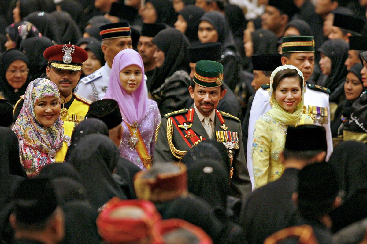 The Sultan of Brunei, with the mother of Princess Ameerah, in yellow, from whom he divorced in 2010