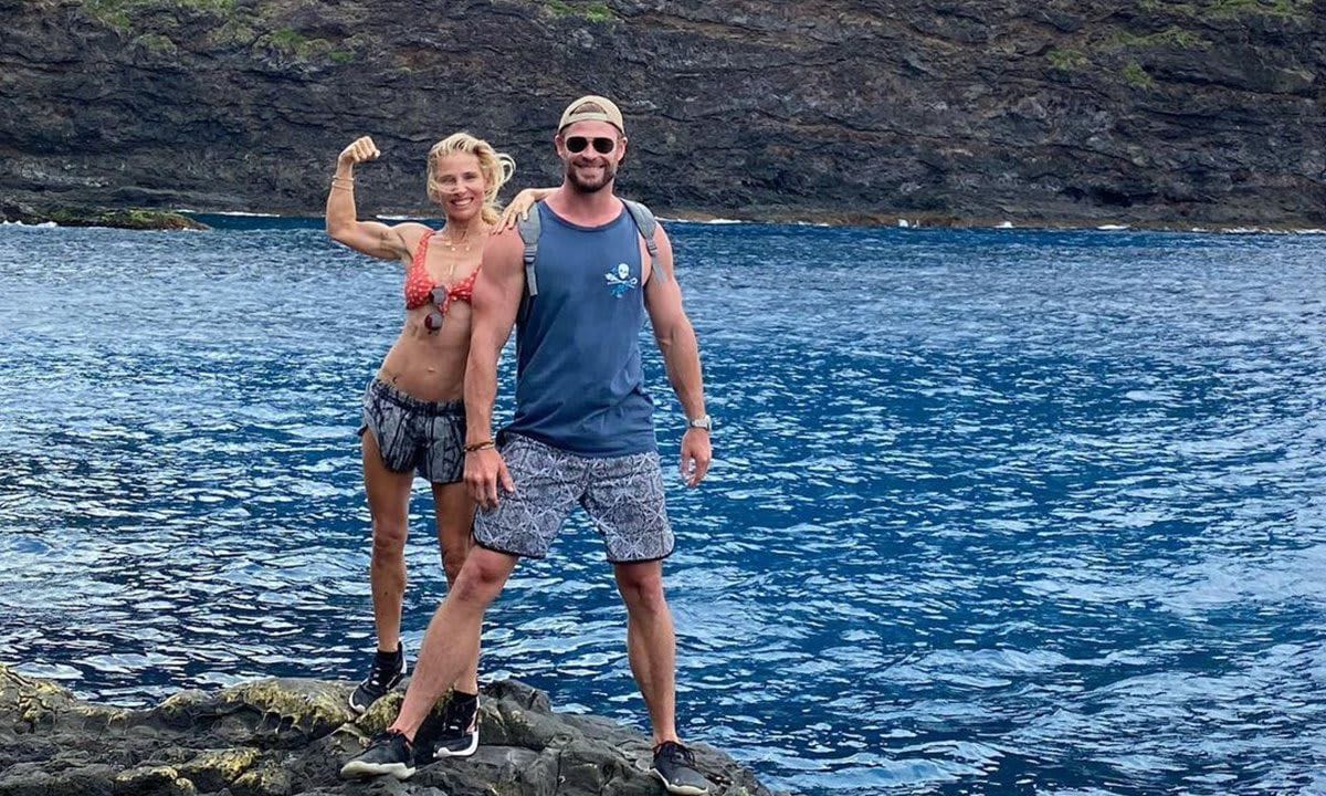 Elsa Pataky flexing next to Chris Hemsworth.